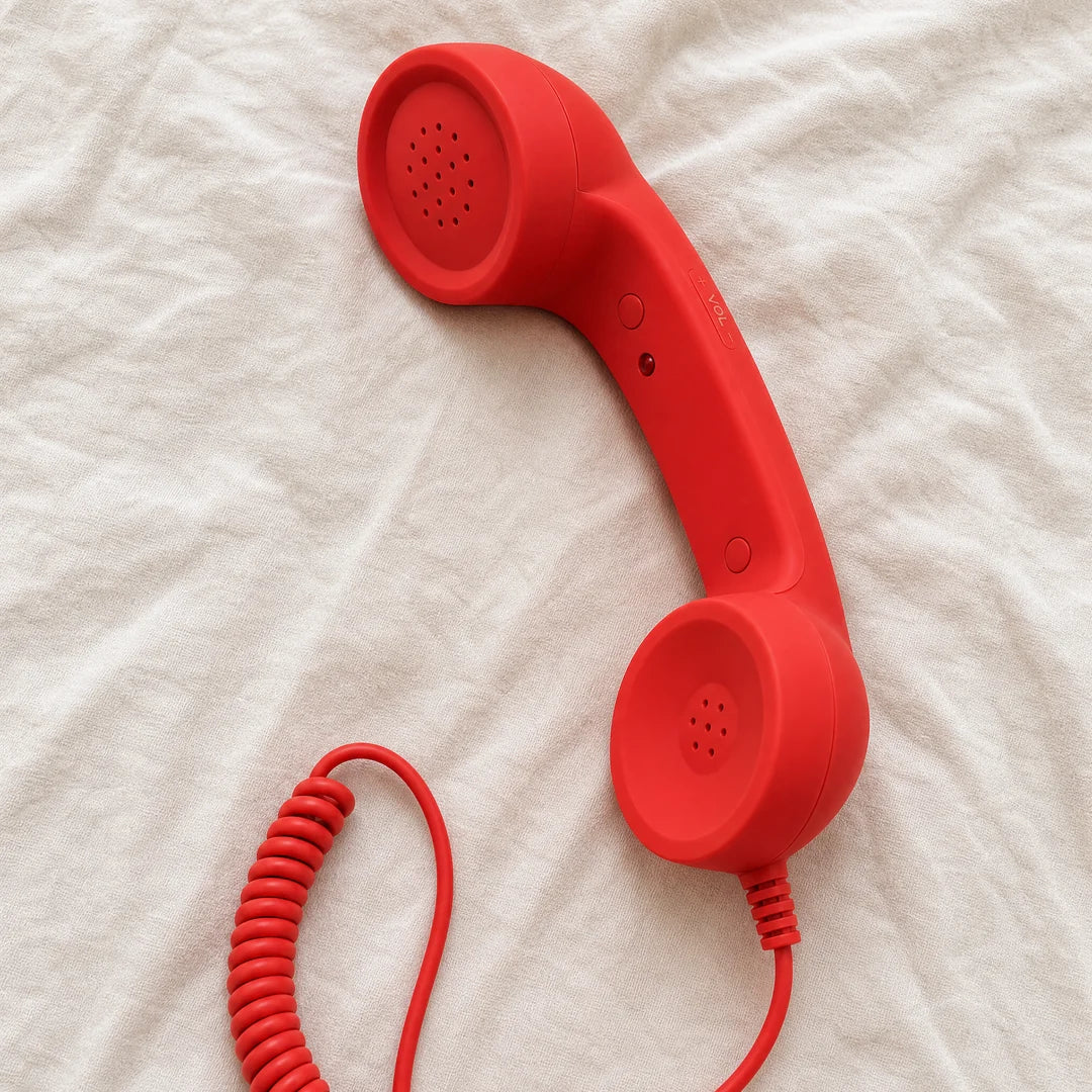 The red DialBoop handset, inner face up